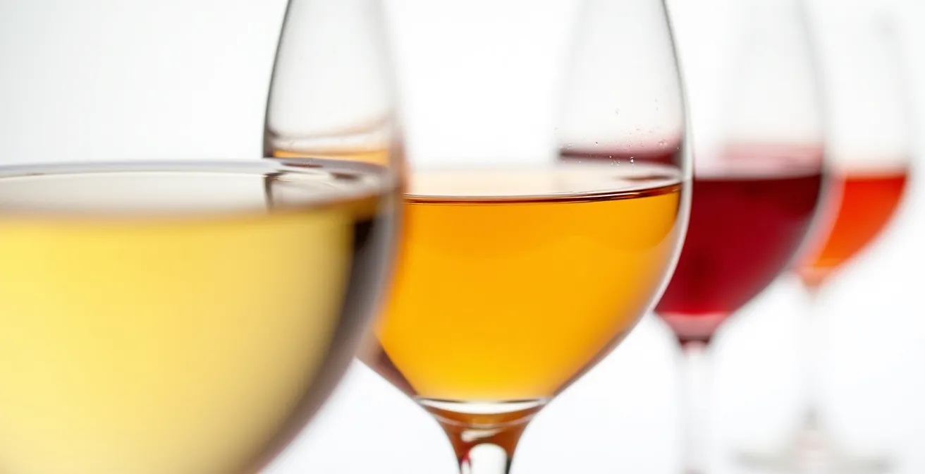 Verschiedene sortenreine Traubensäfte in Weingläsern von hell bis dunkelrot aufgereiht